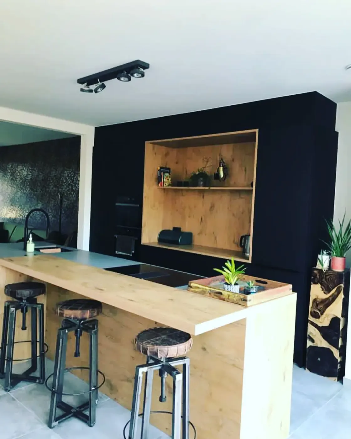 Keuken met een zwart geschilderde wand boven het werkblad